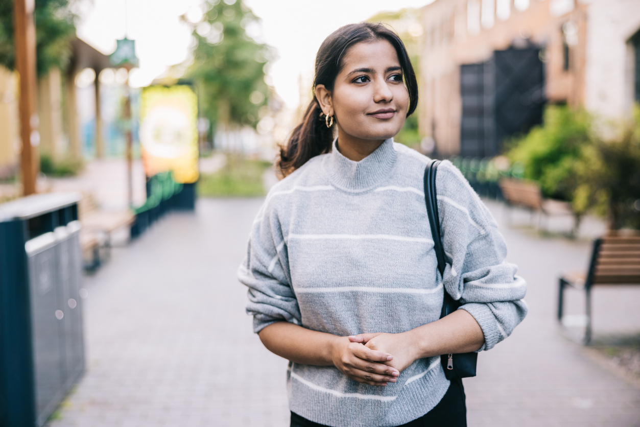 Indian businesswoman heads to her office with a positive expression