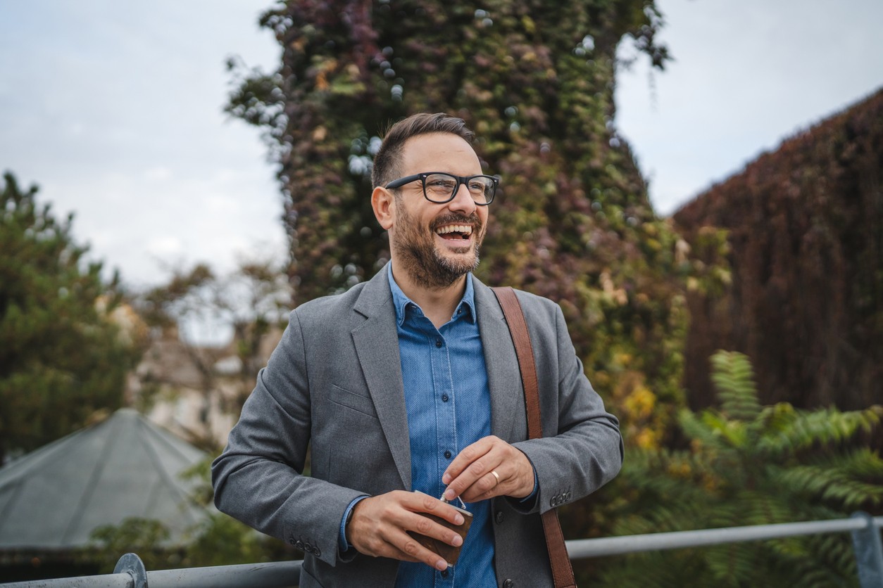Adult man businessman open and hold hip flask during workday